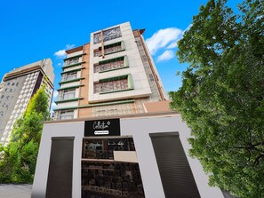 A modern building with a sign that reads 'Collection Company-Serviced.' - Deluxe With Balcony Arjun International (Lucknow)