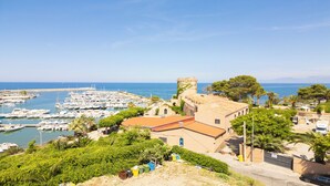 A coastal town with a marina, historic buildings, and lush greenery. - La Casa della Zia (San Nicola l'Arena)