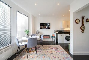 Una cucina moderna con una TV a schermo piatto, un camino e un'area pranzo con tavolo e sedie.