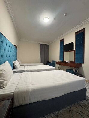 A hotel room with two beds, a television, and a desk. - Vivian Al-Shasha Hotel (Makkah)