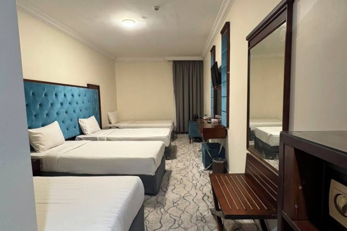 Deluxe Quadruple Room | Peralatan tempat tidur premium, bar mini, peti besi dalam bilik, meja 