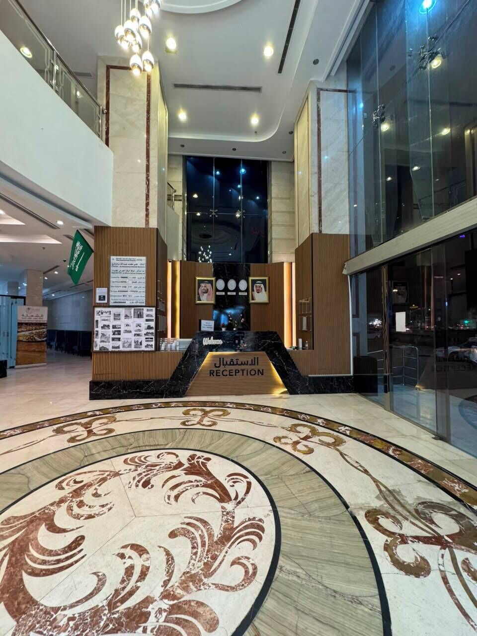 A reception area with a marble floor, a reception desk, and a glass wall.