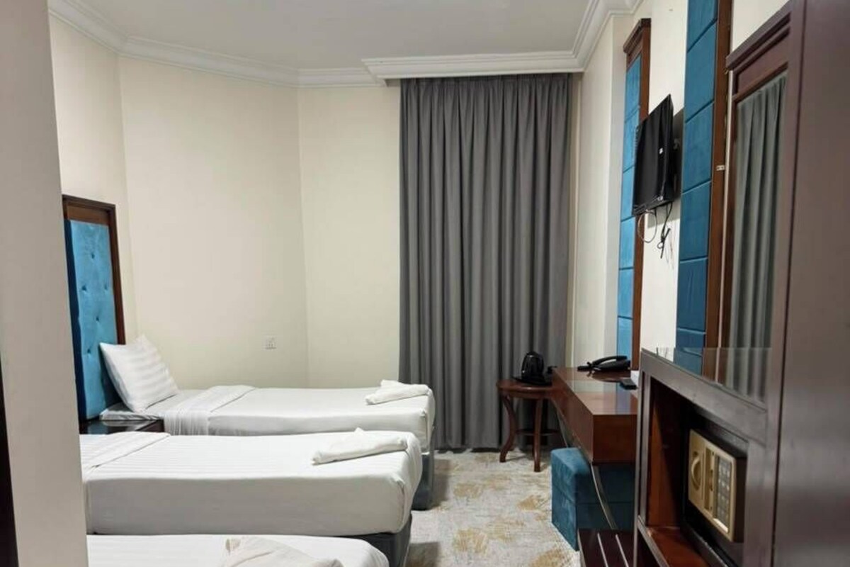 Deluxe Triple Room | Peralatan tempat tidur premium, bar mini, peti besi dalam bilik, meja 