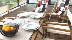 A dining table set for four with two chairs, a bowl of lemons, and a glass of water. - The Ondella T2 in Porticcio with a garage (Grosseto-Prugna)