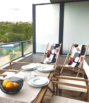 A dining table set for four with two chairs, a bowl of lemons, and a glass of water. - The Ondella T2 in Porticcio with a garage (Grosseto-Prugna)
