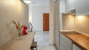 Una cocina moderna con encimera de madera, horno empotrado y una lámpara de pared.