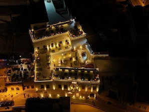 Um edifício de vários andares com um pátio central, varandas e áreas de estar ao ar livre.