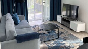 En moderne stue med sofa, TV og sofabord.