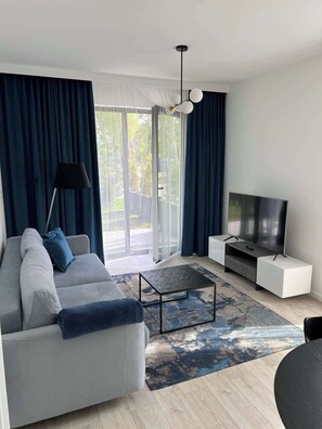 Ein modernes Wohnzimmer mit einer Couch, einem Fernseher und einem Couchtisch.
