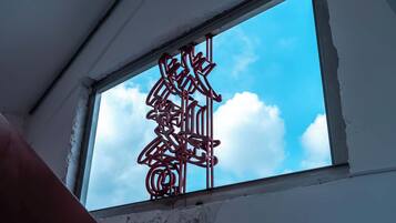 Janela com um detalhe metálico decorativo e céu azul límpido.