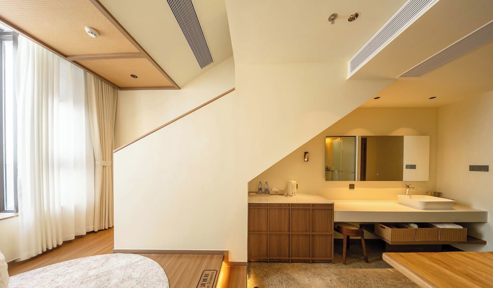 A modern bathroom with a large mirror, wooden cabinets, and a built-in sink.