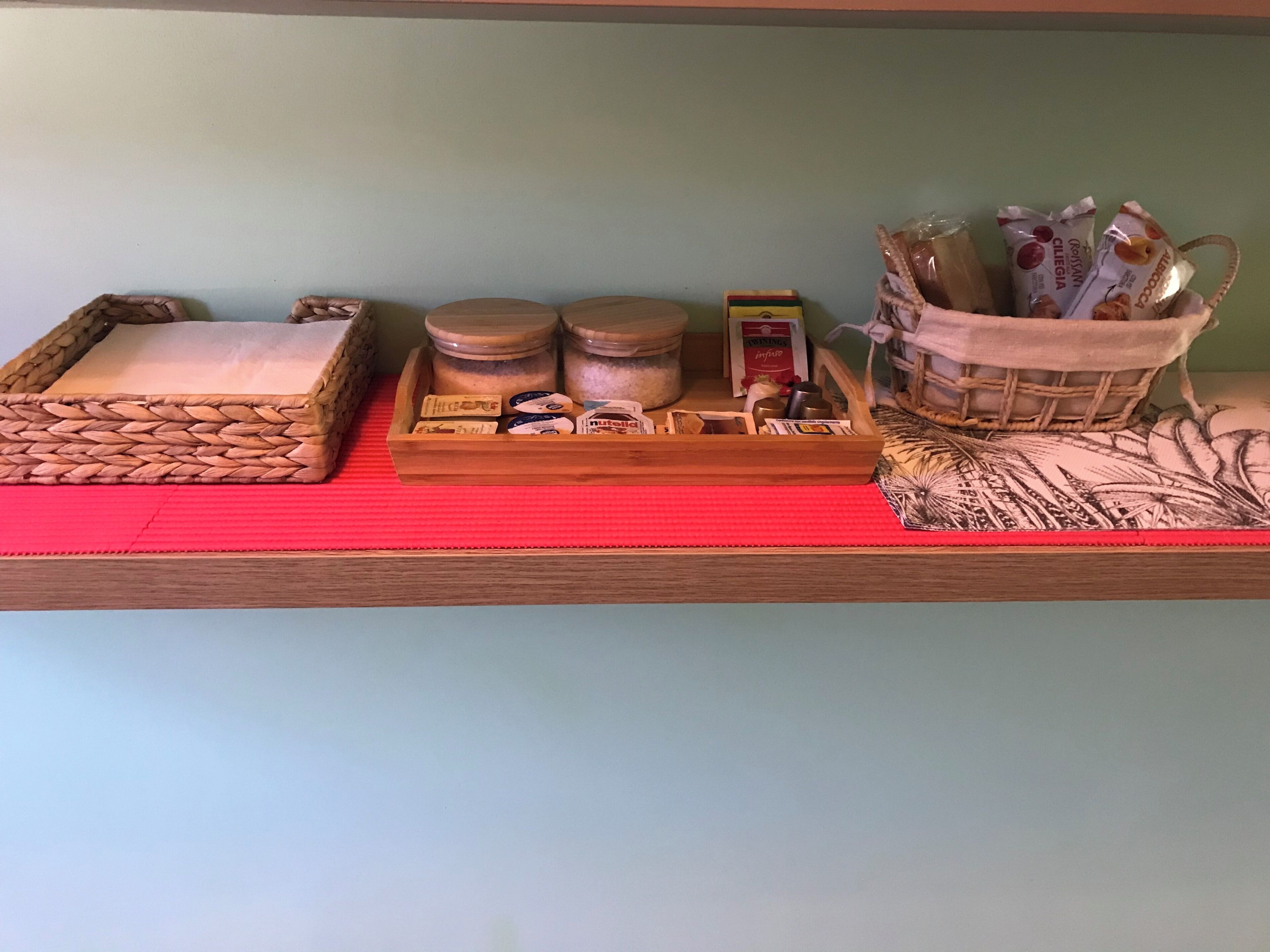Un estante con frascos, una bandeja y una cesta con diversos objetos.
