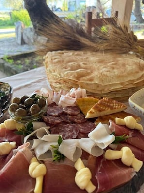 Una tabla de embutidos con diferentes carnes, quesos y aceitunas.