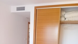 Une chambre à coucher avec un lit, une armoire en bois et un placard blanc.