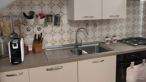 A kitchen with white cabinets, a sink, a stove, and a dishwasher. - ON THE SEA Casalbordino Lido Costa dei Trabocchi (Termini)