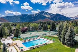 A hotel with a swimming pool, tennis courts, and a mountainous backdrop. - Atelier Lookout - 2BD Condo Baldy Views + Pool (Sun Valley)
