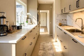 Una cocina moderna con una isla central, electrodomésticos integrados y vistas al área de estar.