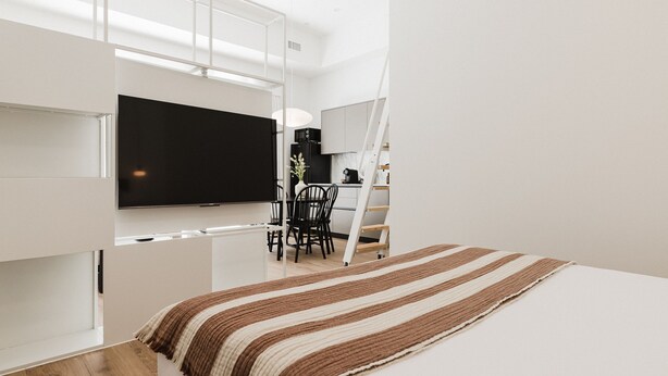 Quarto moderno e minimalista com uma cama, TV de tela plana, área de refeições e escada.