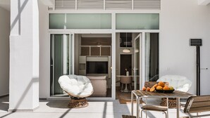 An outdoor seating area with a table, chairs, and a wicker chair. - Comfort Design and a Terrace Facing the Turia Gardens in Valencia (Valencia)