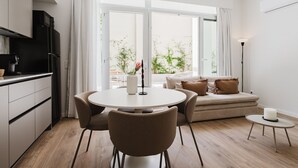 A modern kitchen with a dining area, a sofa, and a small table with a candle. - Comfort Design and a Terrace Facing the Turia Gardens in Valencia (Valencia)
