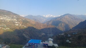 A mountainous landscape with a gas station in the foreground. - Hotel Himalayan View  (Ukhimath)