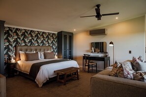 A bedroom with a bed, a desk, a chair, and a ceiling fan.
