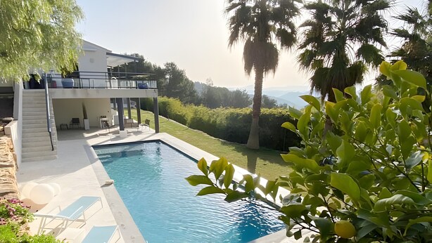 A rectangular swimming pool with lounge chairs, a covered seating area, and a view of the surrounding landscape. - Between Sea and Pine Forest (Pool, Spa Jacuzzi, Sauna) – Aubergine Room (Bandol)