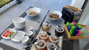 Una mesa dispuesta con tazones de granola, frascos de miel y una bandeja de calcetines coloridos.