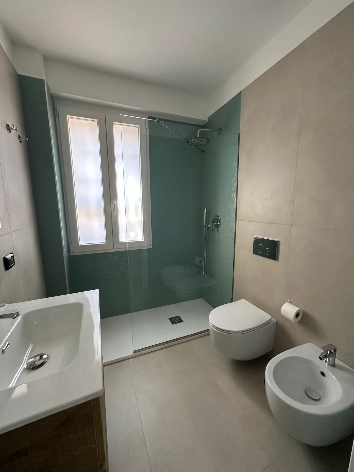 Un baño moderno con ducha, inodoro, bidé y lavamanos.