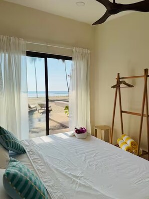 A bedroom with a bed, a view of the beach, a ceiling fan, and a wooden ladder. - Beachfront House with Private Pool, near Troncones (Gro.)