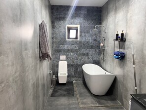 A modern bathroom with a freestanding bathtub, a toilet, and a shower area. - Big and comfortable villa (Shuvelan)