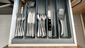 Laatikko, jossa on siististi järjestettynä hopeaesineitä, kuten haarukoita, veitsiä ja lusikoita.