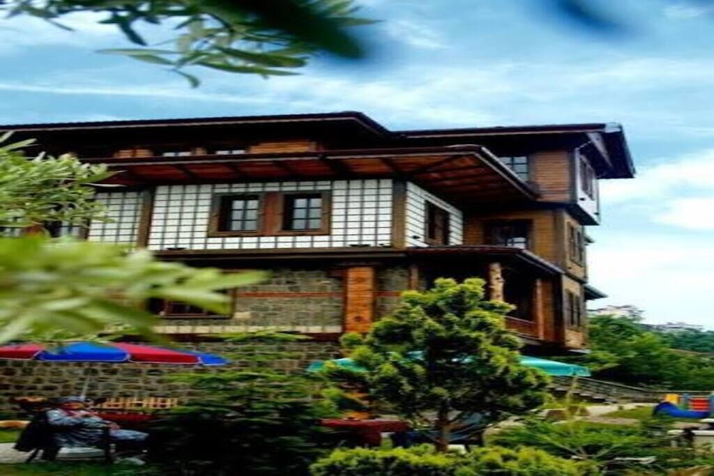 A traditional building with a multi-story structure, wooden beams, and a stone base.