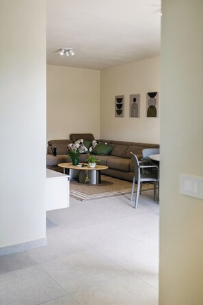 Ein modernes Wohnzimmer mit einer Couch, einem Couchtisch und Sesseln.