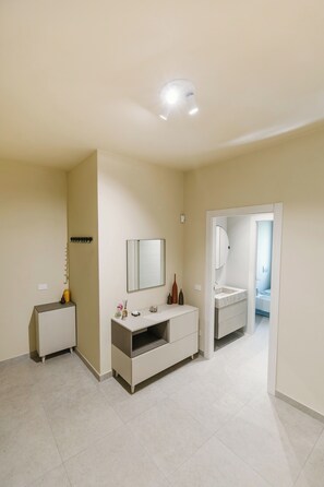 A bathroom with a sink, mirror, and a shower visible through an open door. - Daulia, apartment in a villa near Soverato, on the Ionian coast of Calabria — open year-round (Marina di Davoli)