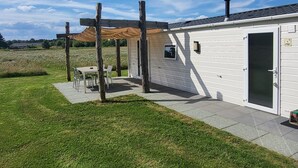 A mobile home with a patio area, a pergola, and a small table with chairs. - Modern Pet-friendly Retreat in Limburg (Heythuysen)