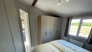 A bedroom with a bed, wardrobe, and a window with a view of the outdoors. - Modern Pet-friendly Retreat in Limburg (Heythuysen)