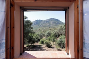 Habitación con vista a un paisaje montañoso a través de una puerta abierta.