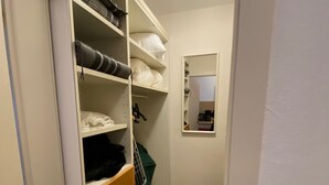 Un dressing avec des étagères, un miroir et un plancher en bois.