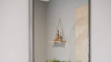 A bathroom with a mirror, a hanging light fixture, and a potted plant.