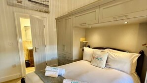 Ein Hotelzimmer mit Bett, Schrank, Tür und kleinem Badezimmer.