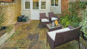 A residential property with a patio area, a brick wall, and a small garden. - Cotswolds 3BD 1 5 Bath Garden City Centre (Cirencester)