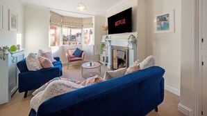 A living room with a fireplace, a television, and a view of the city. - Cotswolds 3BD 1 5 Bath Garden City Centre (Cirencester)