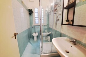 A bathroom with a glass-enclosed shower, a sink, a toilet, and a bidet. - Among the historic alleys of Rome (Domus Viola) (Roma)
