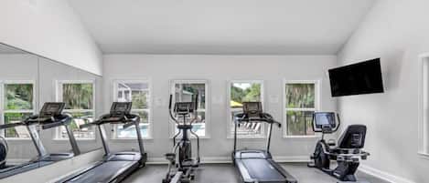 A fitness room with treadmills, elliptical machines, and a rowing machine.