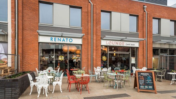 Un immeuble abritant un café appelé « RENATO » et un bar-salon.