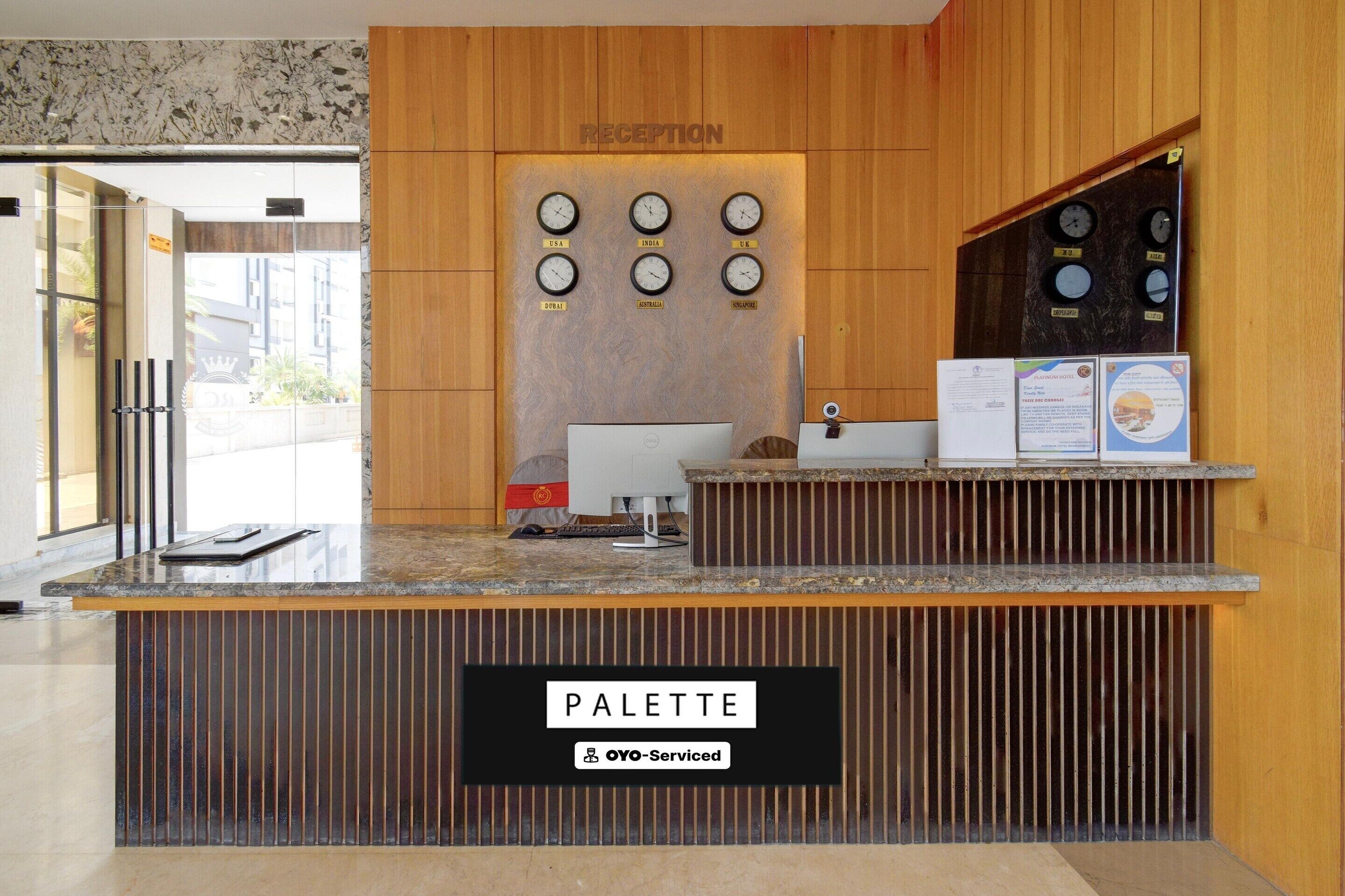 A reception desk with a sign reading 'PALETTE' and a 'RECEPTION' sign above it.