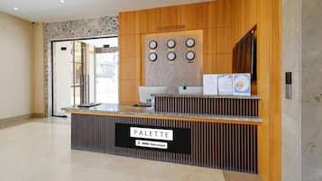 A reception desk with a sign reading 'PALETTE & 9yo Service'.