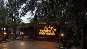 A sign for 'Ekant Jungle Homestay' with a rustic building and palm trees.