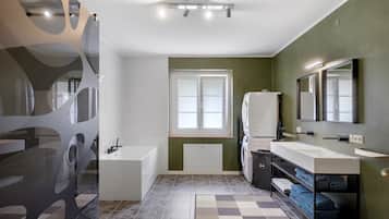 Un baño moderno con una bañera, un espejo grande y un ventanal.